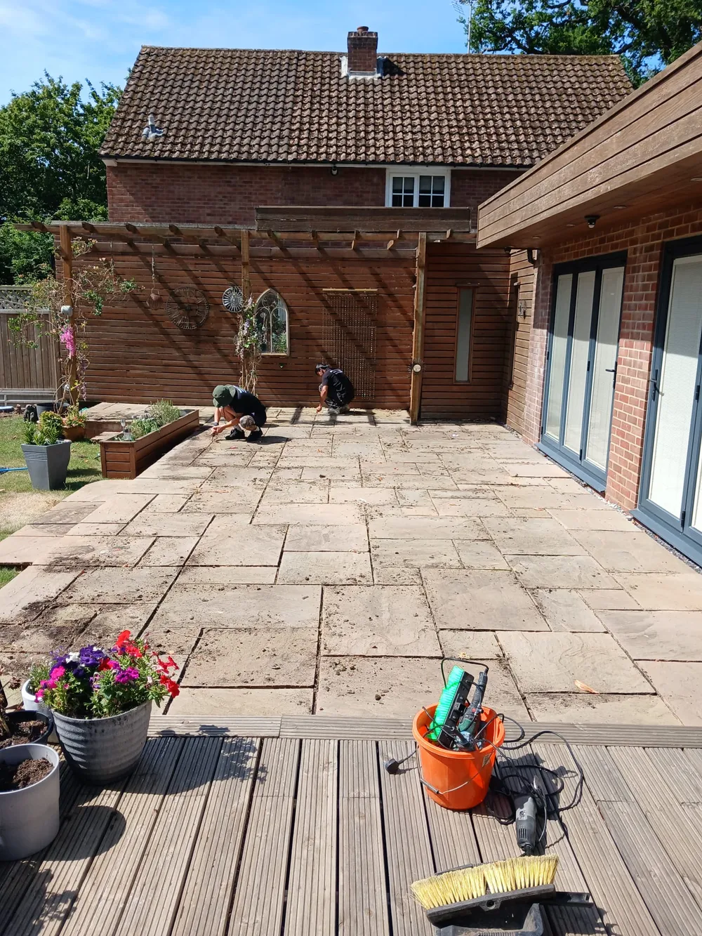 Soiled natural stone patio before professional jet washing